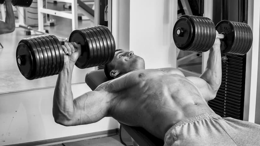 man doing heavy dumbbell bench press