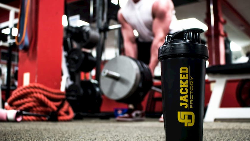 man using a jacked factory shaker while doing landmine rows