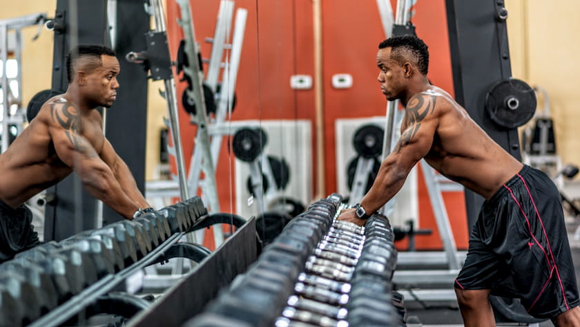 man using the free weight section of the gym